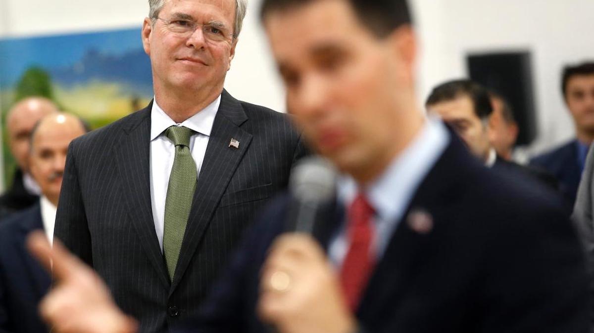 Republican presidential candidate, former Florida Gov. Jeb Bush listens as Wisconsin Gov. Scott Walker answers a question Monday in Waukesha, Wis.