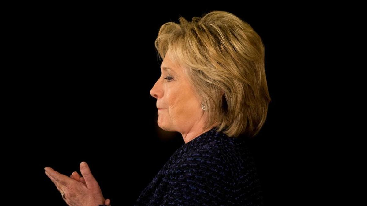 Democratic presidential candidate Hillary Clinton listens to Transportation Secretary Anthony Foxx at a rally Monday, Jan. 11, 2016, in Waterloo, Iowa.