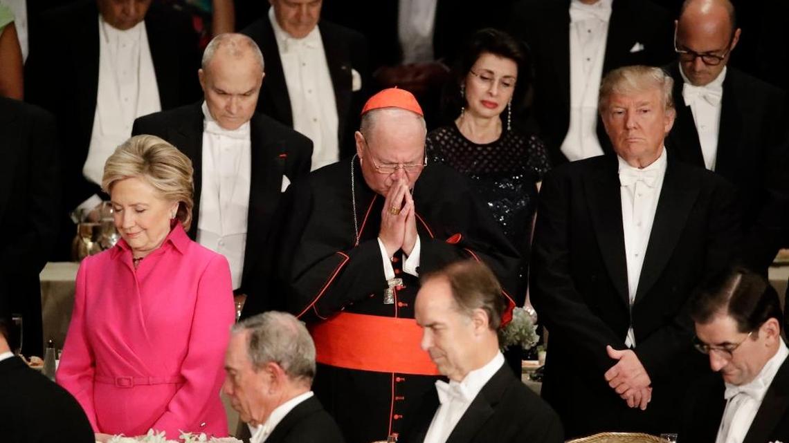 Cardinal Timothy Dolan, center, Democratic presidential candidate Hillary Clinton, left, Republican presidential candidate Donald Trump, right, stand during the invocation at the 71st Annual Alfred E. Smith Memorial Foundation Dinner Thursday, Oct. 20, 2016, in New York.