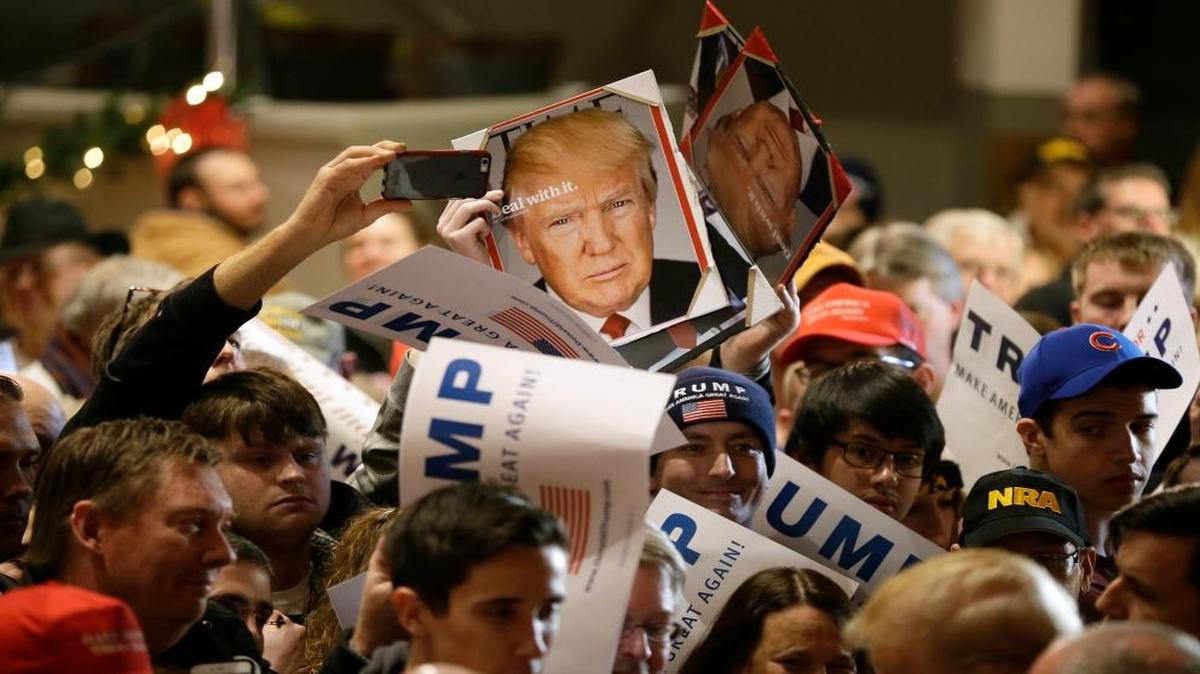 Audience members hold signs to be autographed by Republican presidential candidate Donald Trump during a campaign rally at the Veterans Memorial Building in Cedar Rapids, Iowa. (AP Photo/Charlie Neibergall)