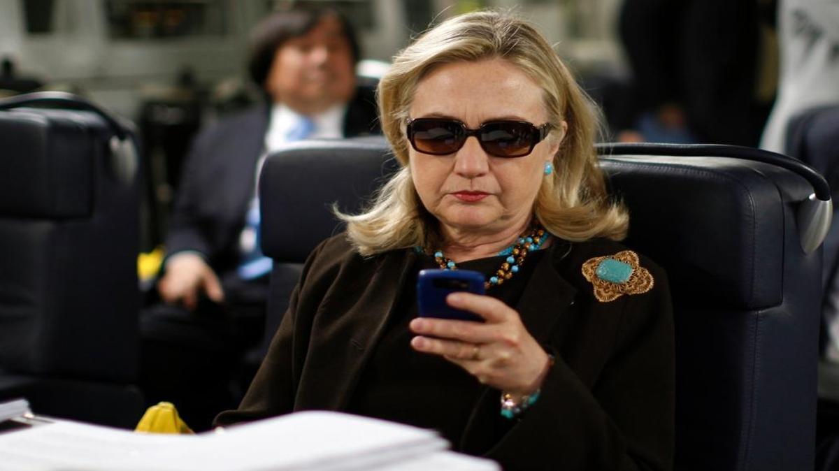 Then-Secretary of State Hillary Clinton checks her BlackBerry from a desk on a C-17 military plane during her flight to Tripoli, Libya, on Oct. 18, 2011.