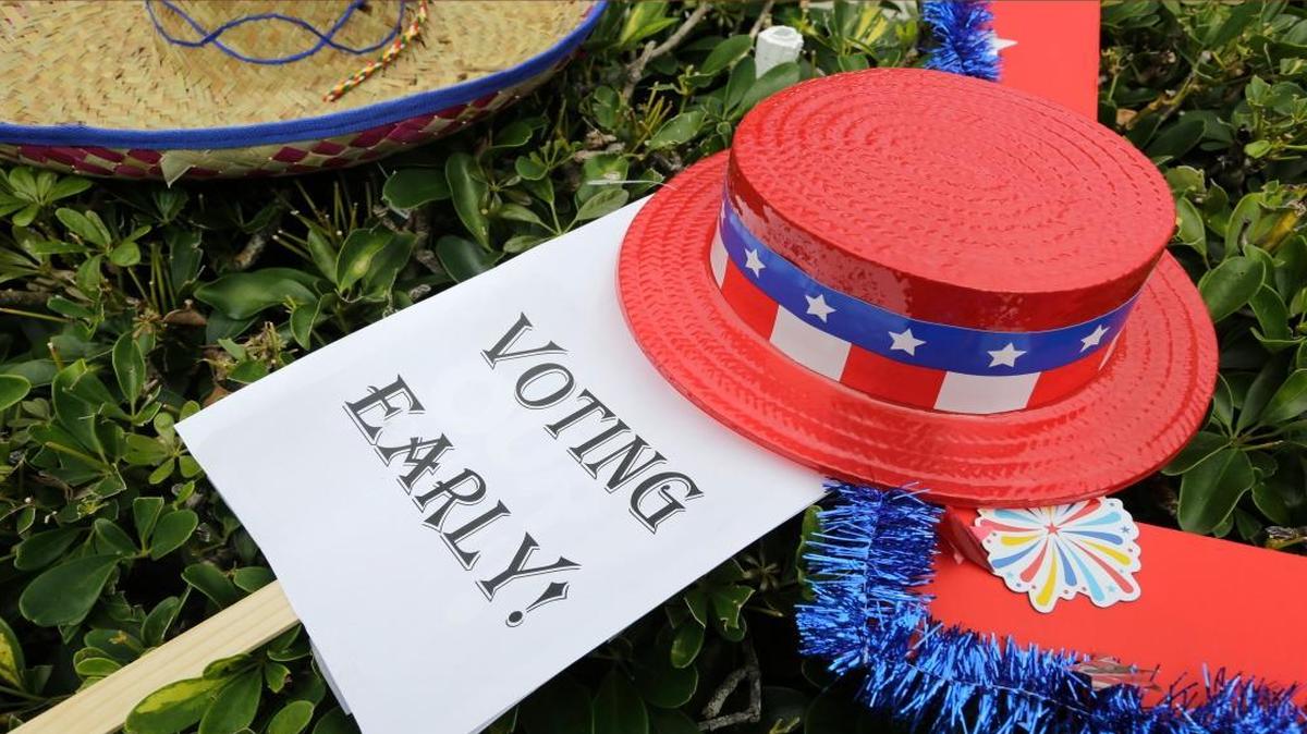 An early voting sign is placed on the grass at an early voting celebration outside Jackson Memorial Hospital on Monday, Oct. 24, 2016, the first day of early voting in Miami-Dade County for the general election.