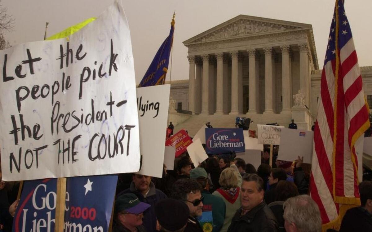 Protesters hold signs and flags in front of the U.S. Supreme Court after the 2000 election resulted in a recount as a result of Al Gore winning the popular vote, but George W. Bush winning more electoral votes. The court decided the outcome in favor of Bush. Experts say the likelihood of a split vote this year between Hillary Clinton and Donald Trump is unlikely, but the polls are close and it’s not out of the question.