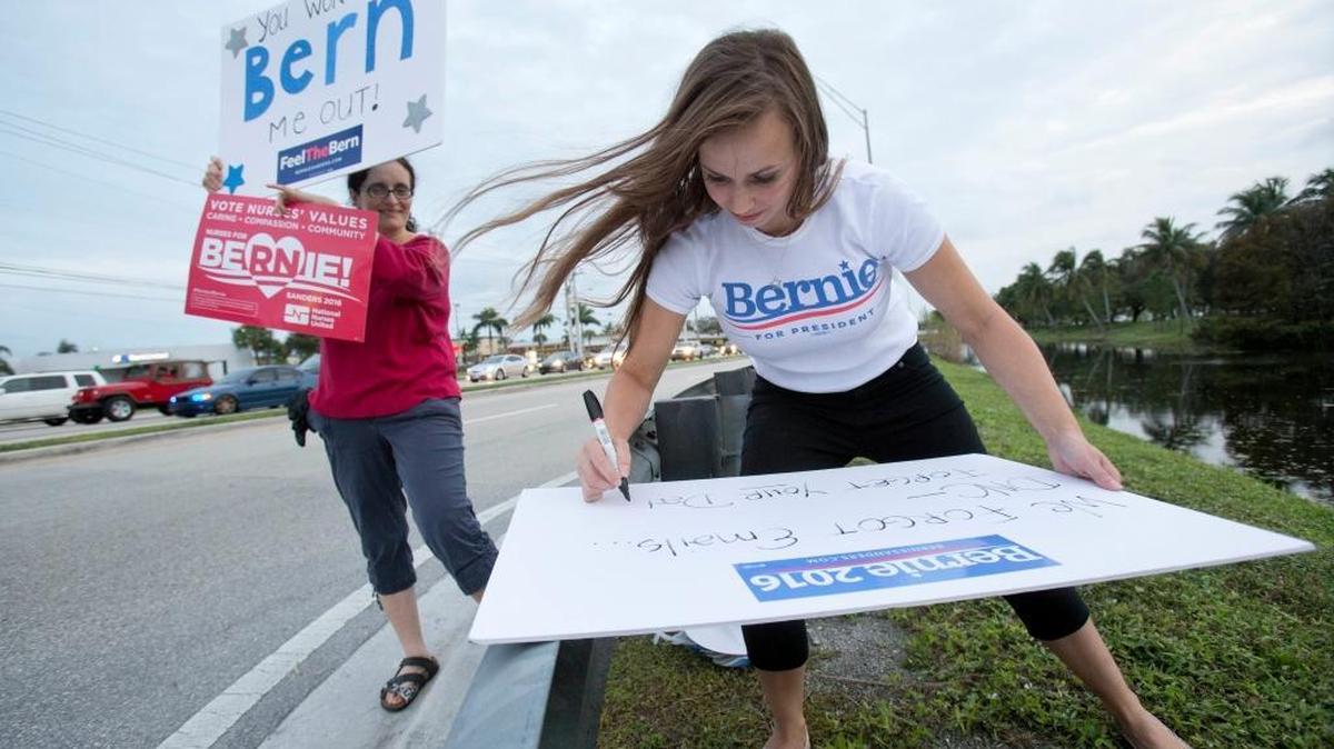 Lorraine Joseph, right, a student nurse at Broward College, makes a sign as Jenny Ellis, left, looks on, in Pembroke Pines, Fla.