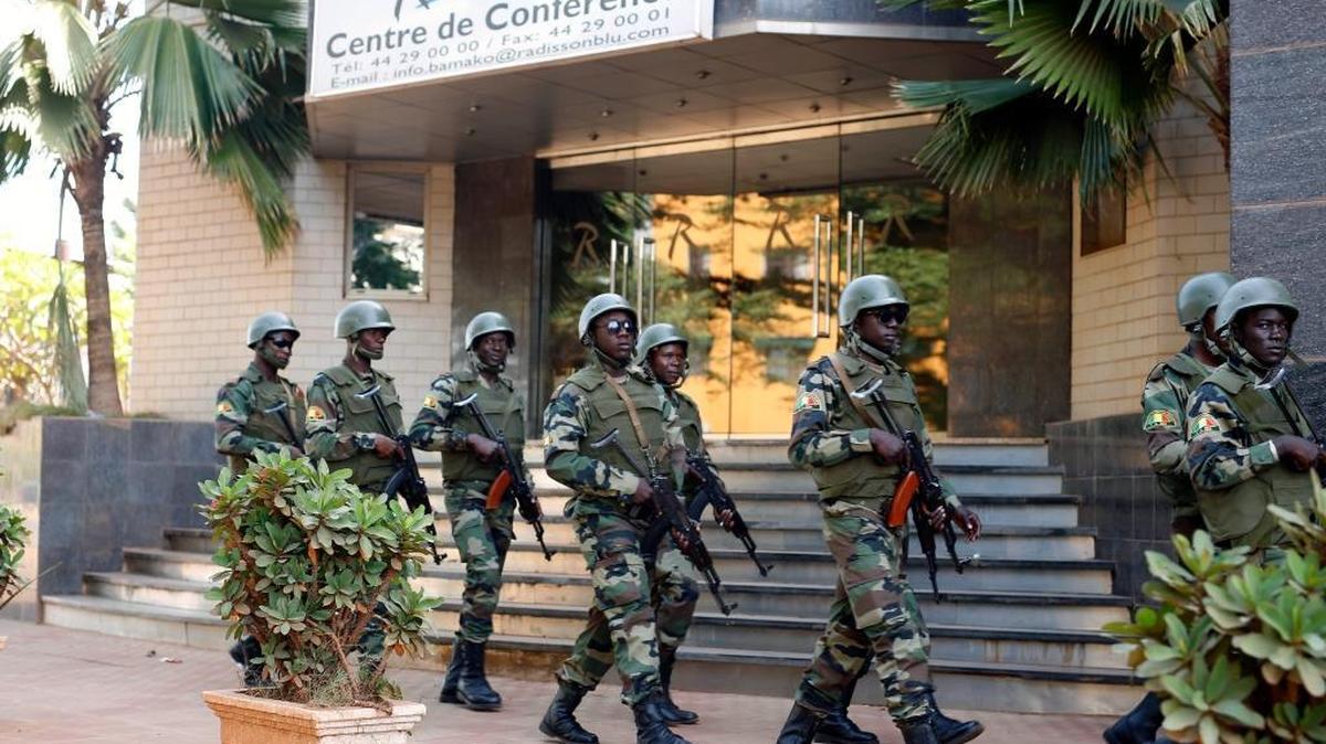 Soldiers from the presidential guard patrol outside the Radisson Blu hotel in Bamako, Mali, Saturday, Nov. 21, 2015, in anticipation of the President's visit. Islamic extremists armed with guns and grenades stormed the luxury Radisson Blu hotel in Mali's capital Friday morning, and security forces worked to free guests floor by floor.