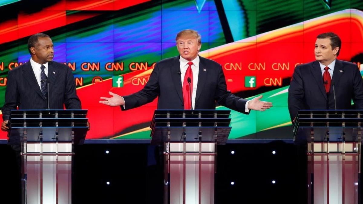 Ben Carson, left, and Ted Cruz, right, look on as Donald Trump speaks during the CNN Republican presidential debate at the Venetian Hotel & Casino on Tuesday, Dec. 15, 2015, in Las Vegas.