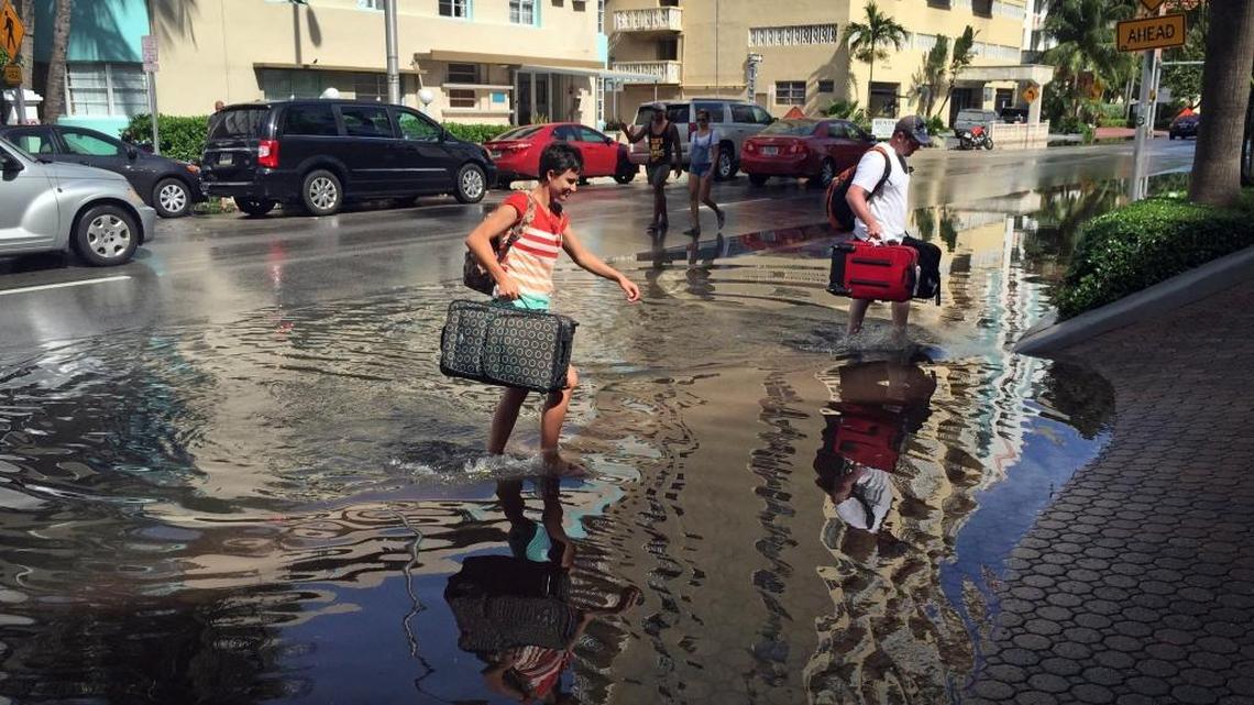 Oakley and Casey Jones, tourists from Idaho Falls, navigate the flooded streets of Miami Beach during a king tide in September.