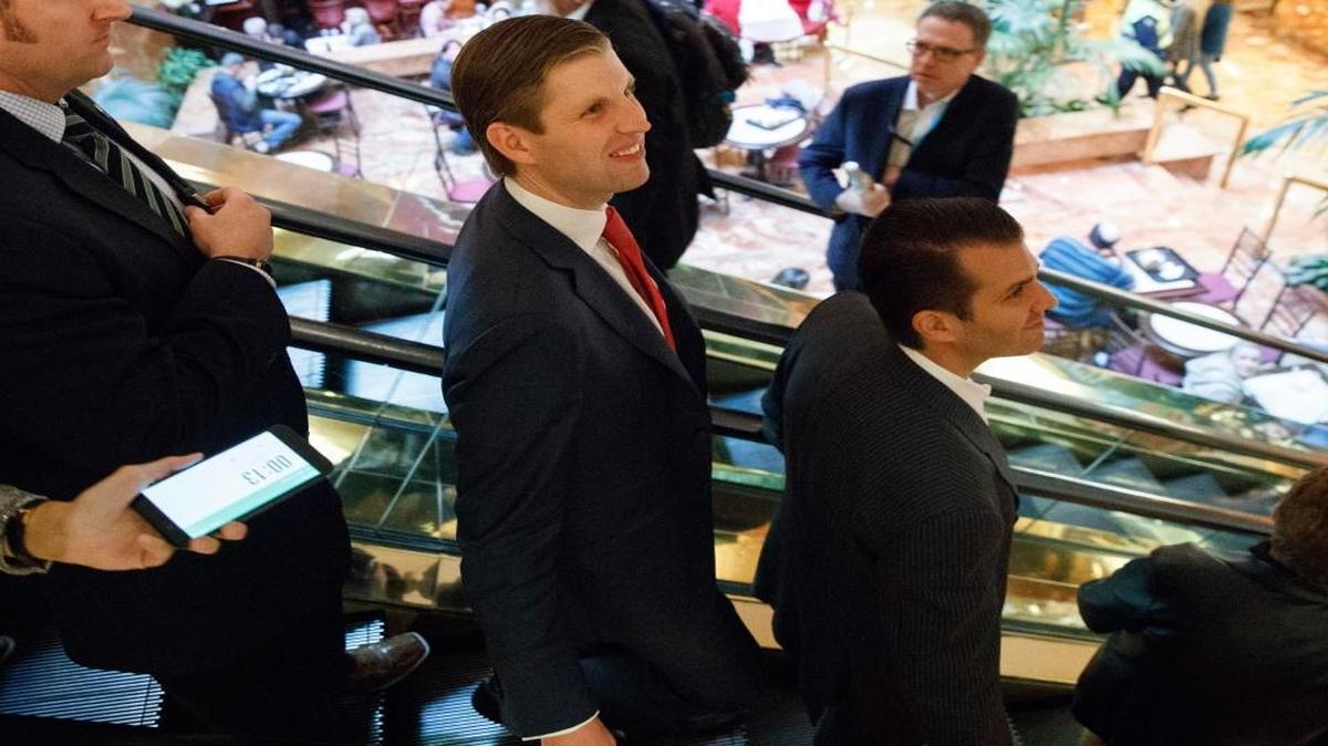 Donald Trump Jr., right, and Eric Trump, center, get on an escalator in the lobby of Trump Tower, Monday, Nov. 14, 2016, in New York.