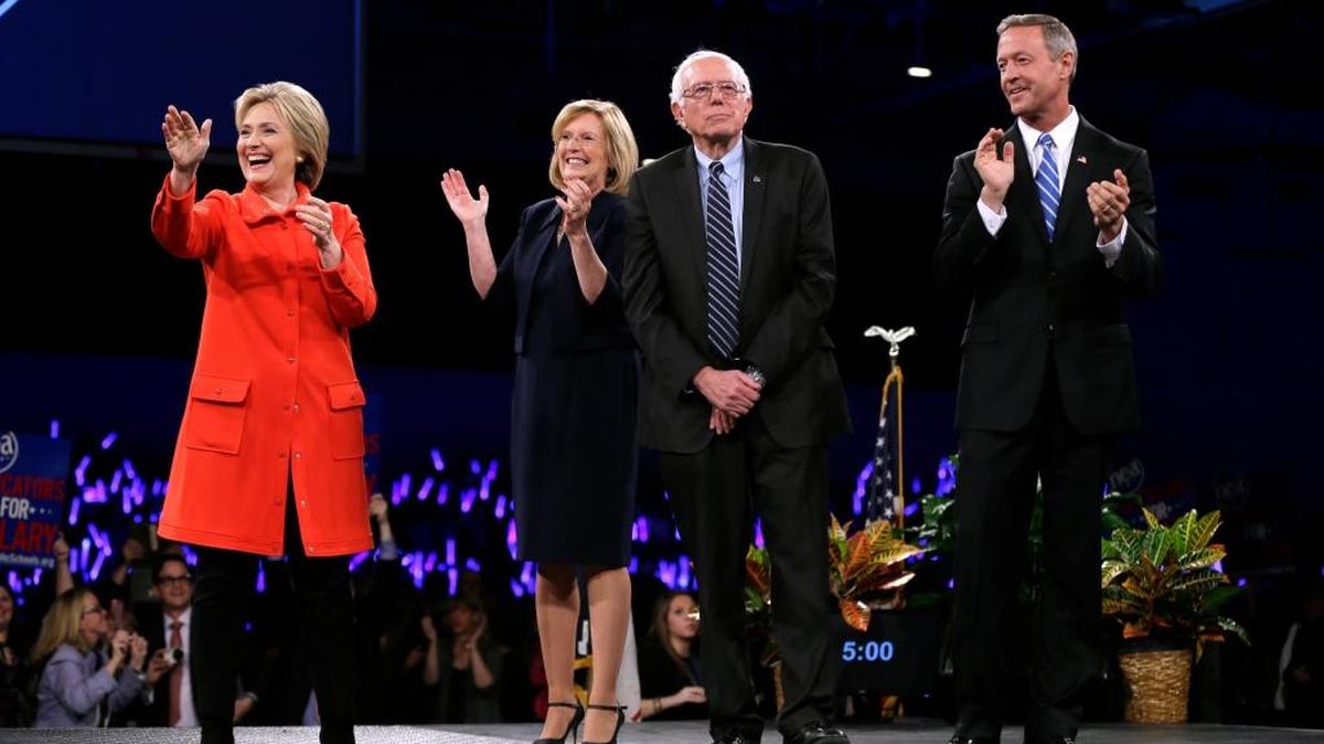 Democratic presidential candidates Hillary Rodham Clinton, left, Sen. Bernie Sanders, I-Vt., second from right, and former Maryland Gov. Martin O'Malley, right, stand on stage together at the start of the Iowa Democratic Party's Jefferson-Jackson Dinner, Saturday, Oct. 24, 2015, in Des Moines, Iowa. Iowa Democratic Party chair Andy McGuire, second from left, looks on.