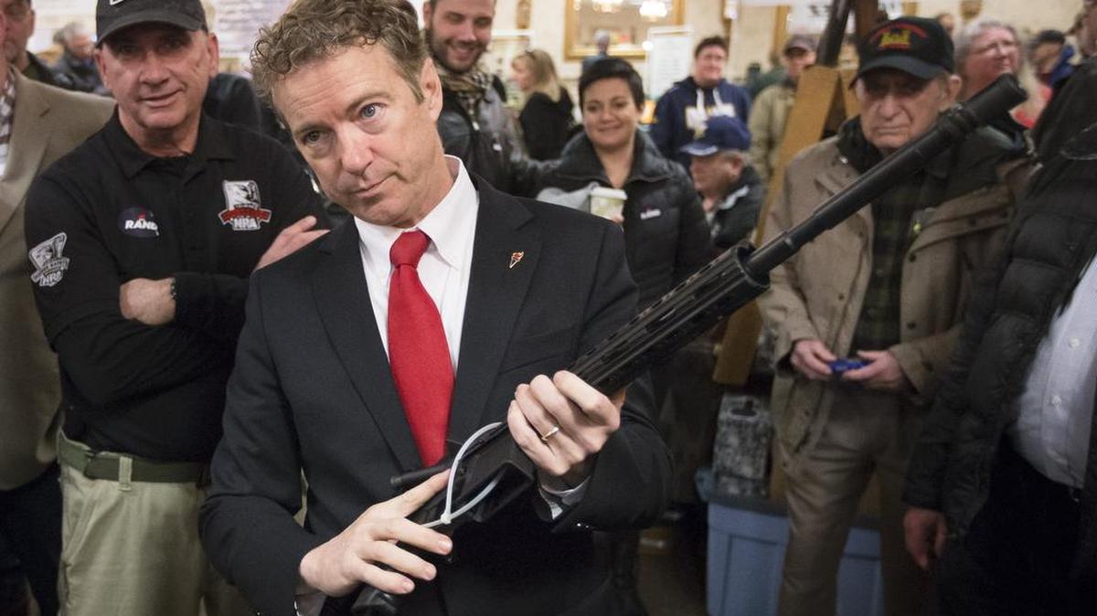 Republican presidential candidate, Sen. Rand Paul, R-Ky., handles a AR-15 style rifle as he meets with customers during a campaign stop at a gun show at Bektash Shrine Center, Saturday, Jan. 23, 2016, in Concord.