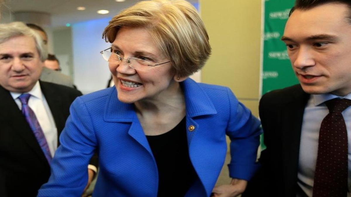 U.S. Sen. Elizabeth Warren, D-Mass., center, greets business leaders during a New England Council luncheon at a hotel in Boston. Larry Zabar, New England Council executive vice president, second from left, looks on.