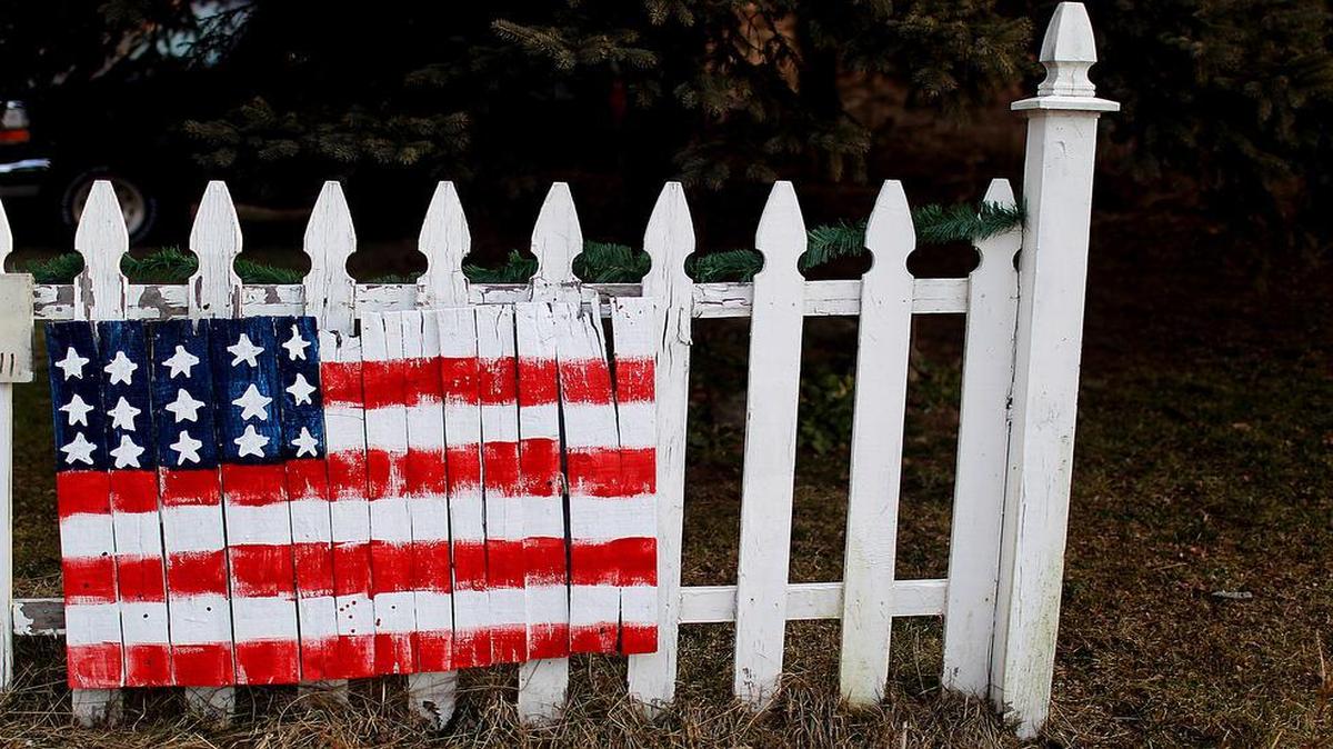 
An American flag decorates a picket fence in Londonderry, N.H., in this 2012 file photo. As it nears another birthday, America is forging the outlines of a new century. The country is moving with remarkable speed to cast aside some of the traditions and mores that dominated American life for centuries.

