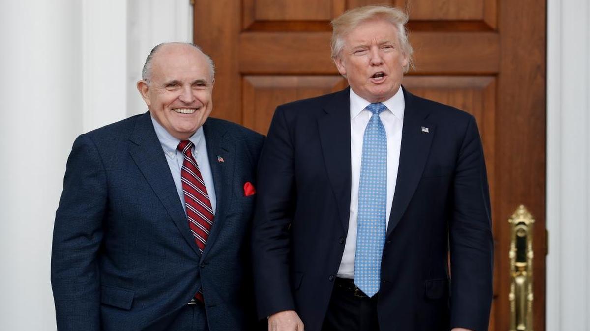 President-elect Donald Trump, right, and former New York Mayor Rudy Giuliani pose for photographs as Giuliani arrives at the Trump National Golf Club Bedminster clubhouse Sunday, Nov. 20, 2016.