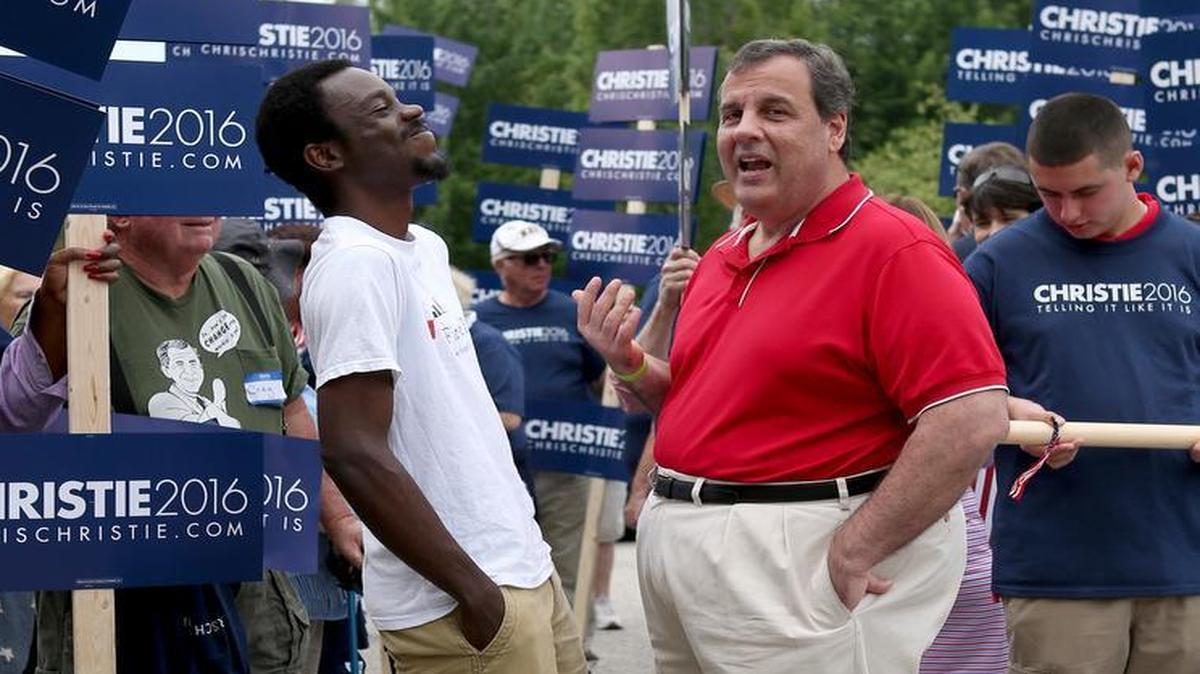 
Republican presidential candidate New Jersey Gov. Chris Christie talks with potential supporter Bernard Botchy of New London, N.H., as they walk in the Fourth of July parade Saturday in Wolfeboro, N.H. 
