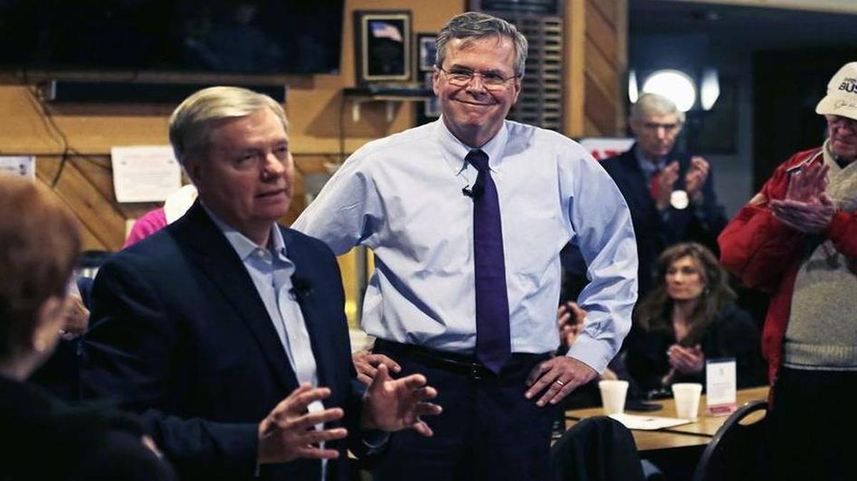 Former Florida Gov. Jeb Bush listens as Sen. Lindsey Graham, R-Seneca, speaks during a campaign stop at an American Legion post in Manchester, New Hampshire, on Jan. 20, 2016.