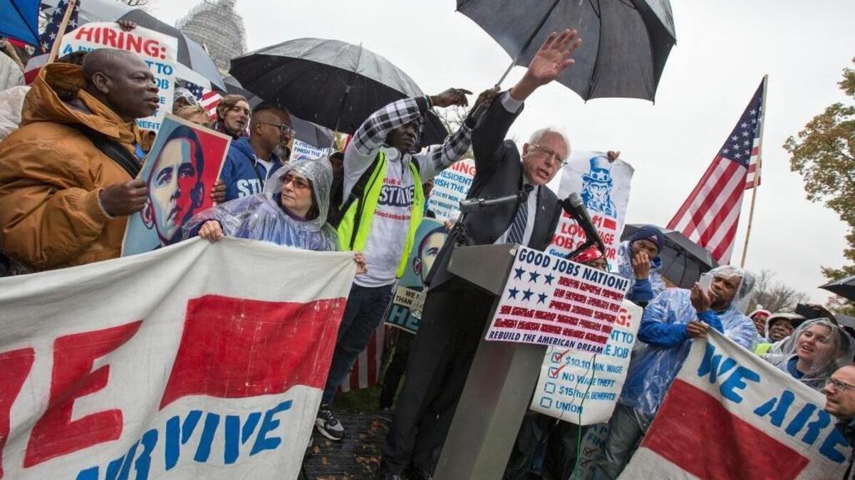 Democratic presidential candidate, Sen. Bernie Sanders, I-Vt. joins low-wage workers, some who labor as cooks and cleaners at the Capitol, as he speaks during a rally to protest what they describe as poverty pay, Tuesday, Nov. 10, 2015, on Capitol Hill in Washington.