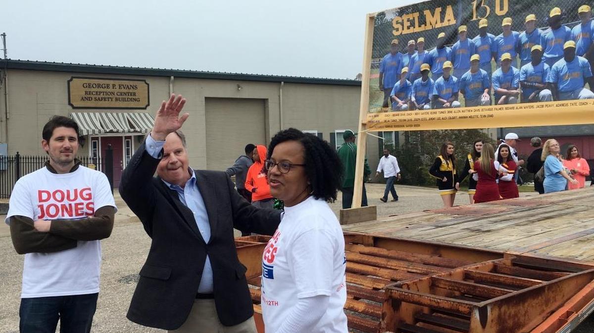 Doug Jones, second form left, the Democratic candidate for U.S. Senate, waves to a supporter as he walks in a Christmas parade, Saturday, Dec, 2, 2017, in Selma, Ala. Jones is trying to shore up support among black voters in his U.S. Senate race against Republican Roy Moore by appealing for an end to the divisiveness that has long been part of the state's politics.