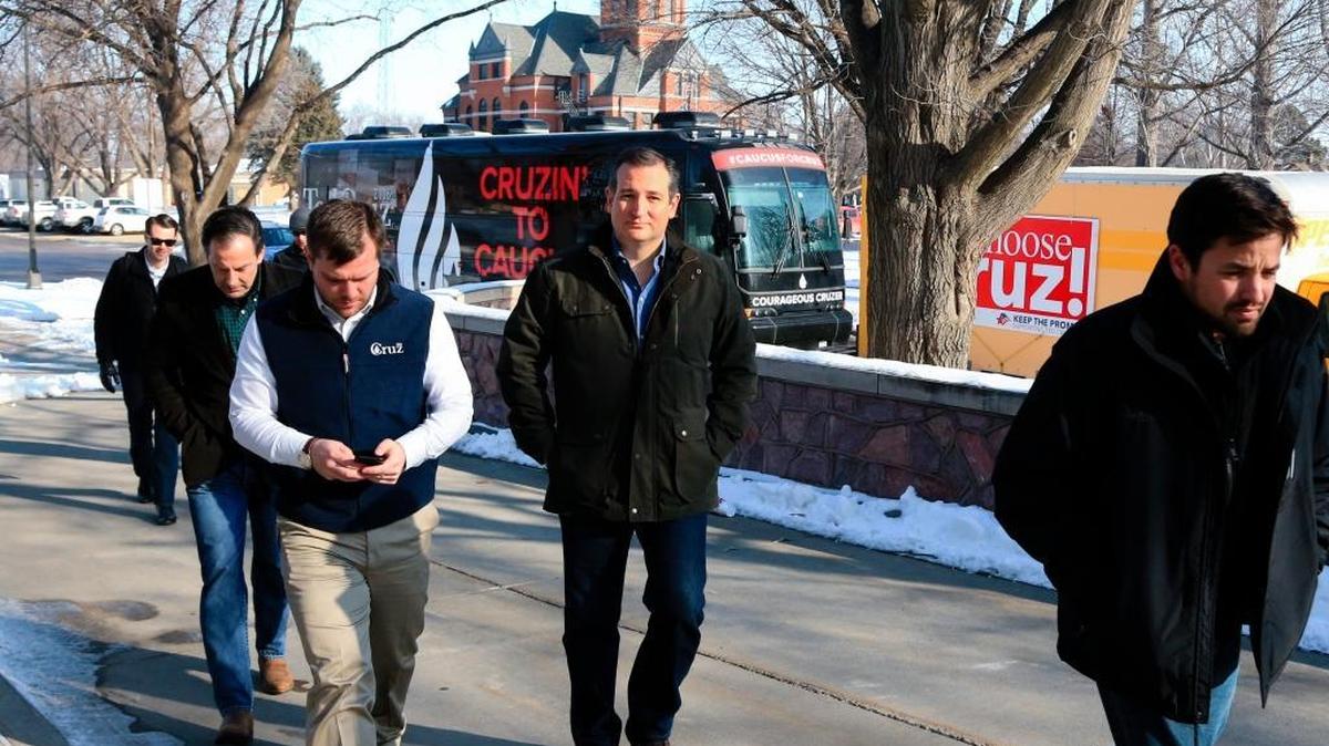 Republican presidential candidate Sen. Ted Cruz, R-Texas, is accompanied by aides as he walks from his campaign bus to the public library in Onawa, Iowa, before a planned campaign event on Tuesday, Jan. 5, 2016.