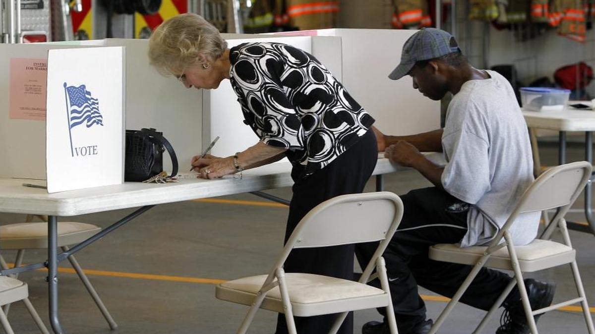 FILE – During 2014 midterm elections, North Carolina voters cast their ballots at the Clayton Fire Station in Johnston County. This November, federal cybersecurity officials will test North Carolina’s electronic voting-related equipment for possible vulnerabilities that hackers could exploit. The partnership is part of a nationwide effort to beef up cybersecurity.