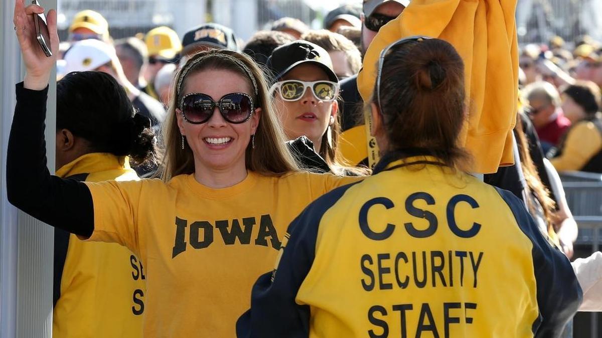 An Iowa fan gets checked by security before the start of the Rose Bowl NCAA college football game against Stanford Friday.