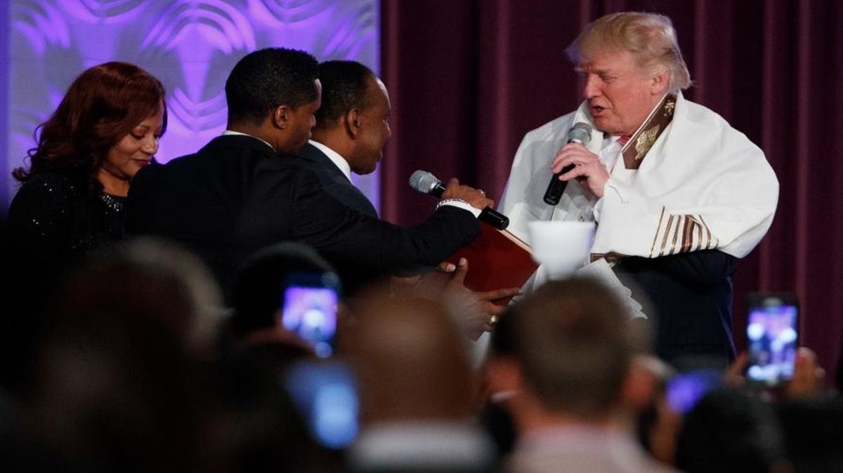 Republican presidential candidate Donald Trump wears a prayer shawl as he is presented with a gift during a church service at Great Faith Ministries, Saturday, Sept. 3, 2016, in Detroit.