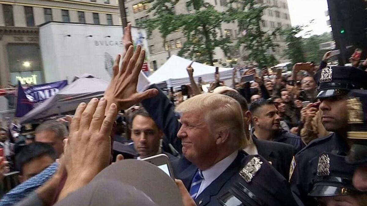 In this image made from video, Republican presidential candidate Donald Trump greets supporters outside his Trump Tower building in New York on Saturday, Oct. 8, 2016. Trump insisted Saturday he would "never" abandon his White House bid, rejecting a growing backlash from Republican leaders nationwide who disavowed the GOP's presidential nominee after he was caught on tape bragging about predatory advances on women.
