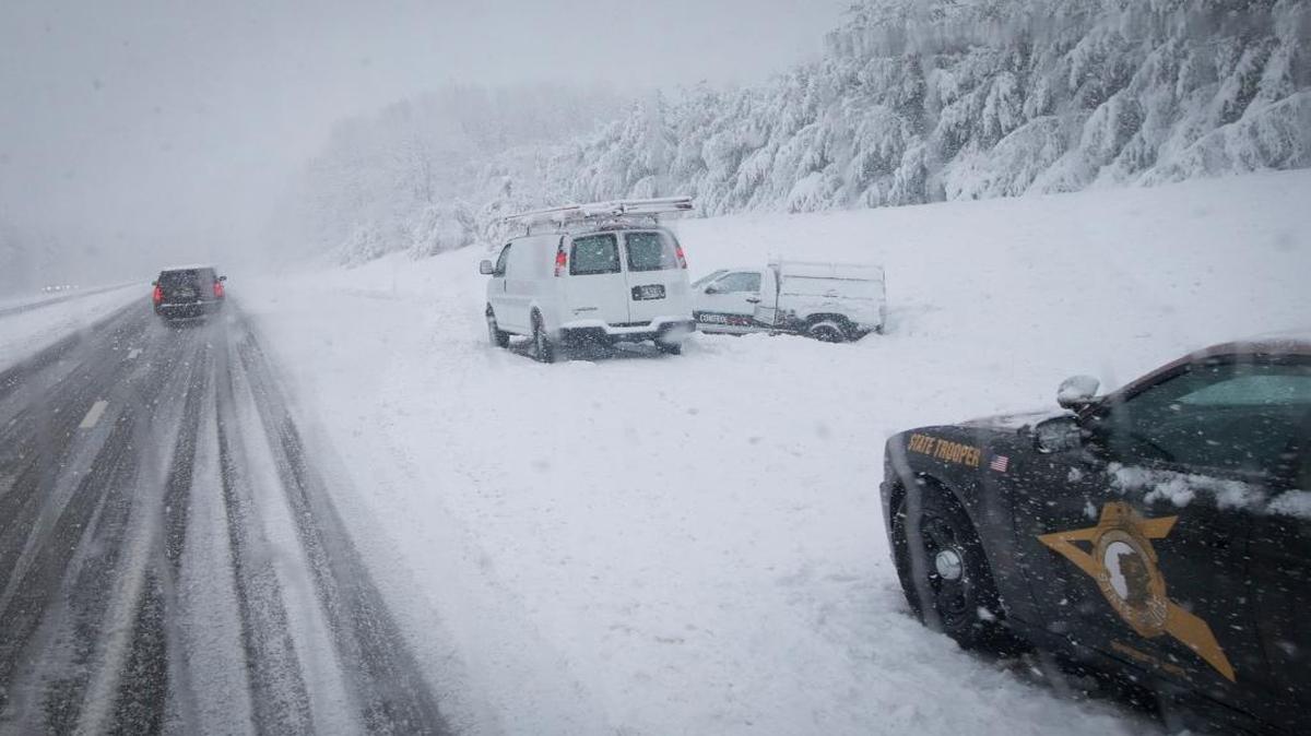 A motorist who slid off Interstate 93 is helped by police Friday near Manchester, New Hampshire. The snowstorm snarled campaign plans across the state, including those of GOP front-runner Donald Trump, who was forced to delay his return to the state from South Carolina. The Republican candidates will debate Saturday night.