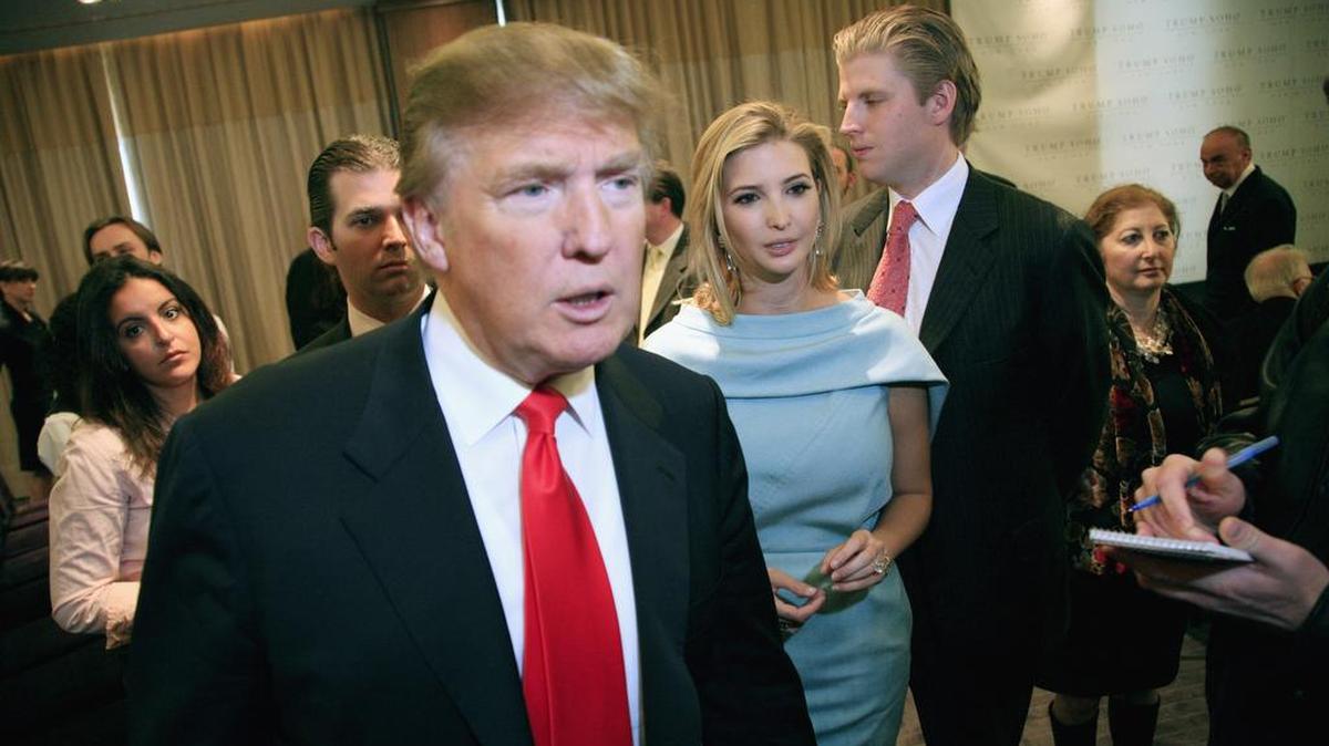 Donald Trump talks with a reporter at the opening of the Trump SoHo New York in April 2010. With him are his children Donald Trump, Jr., left, Ivanka, and Eric.