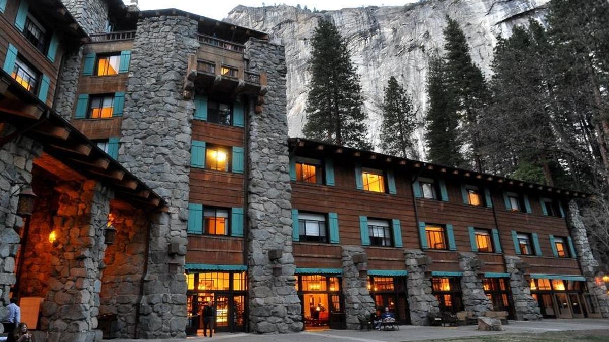 In this file photo, the historic hotel long known as the Ahwahnee is lit up as dusk falls over Yosemite Valley.