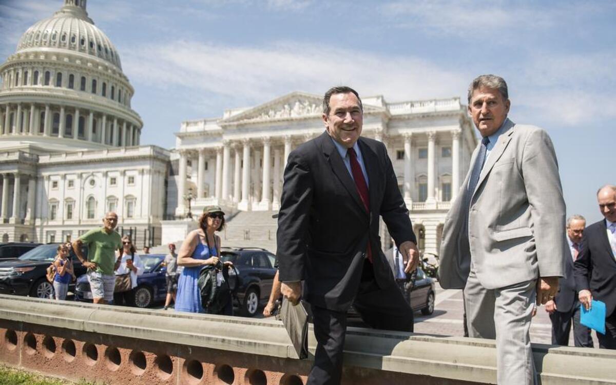 Sens. Joe Donnelly, D-Ind., left, and Joe Manchin, D-W.Va., arrive for news conference on the east lawn of the Capitol to unveil a new economic agenda titled "A Better Deal on Trade and Jobs" on August 2, 2017.