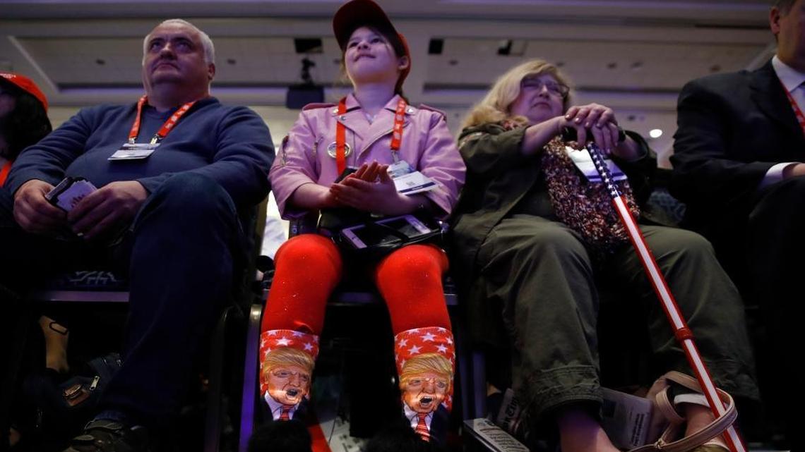 Millie March, 12, of Fairfax, Va., center, wears socks featuring President Donald Trump while awaiting his speech to the Conservative Political Action Conference (CPAC), at National Harbor, Md., Friday, Feb. 23, 2018.