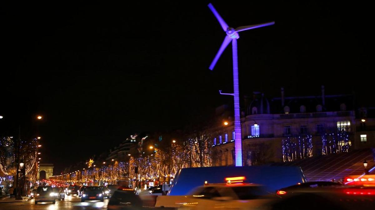 A power-generating windmill turbine is seen on the Champs Elysees with the Arc de Triomphe in background at left, as part of the COP21, the United Nations Climate Change Conference, in Paris on Wednesday.