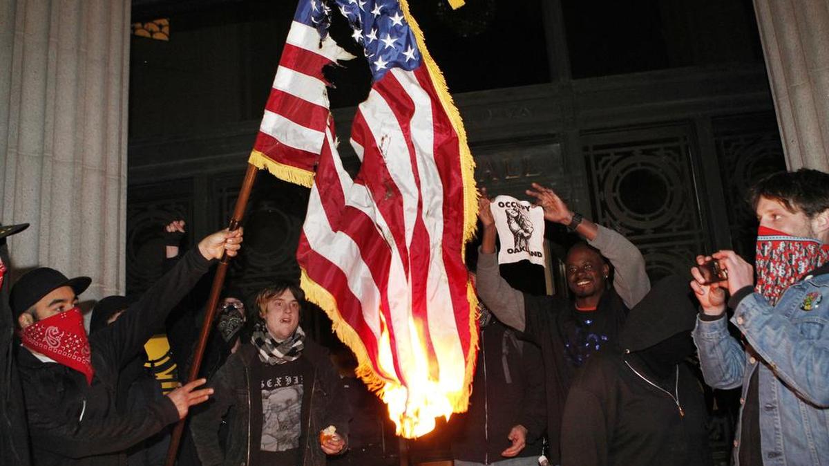 Occupy Oakland protestors burn an American flag found inside Oakland City Hall during an Occupy Oakland protest on the steps of City Hall, Saturday, January 28, 2012, in Oakland, Calif.
