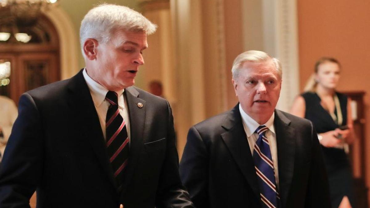 Sen. Bill Cassidy, R-La., left, and Sen. Lindsey Graham, R-S.C., right, talk while walking to a meeting on Capitol Hill in Washington.