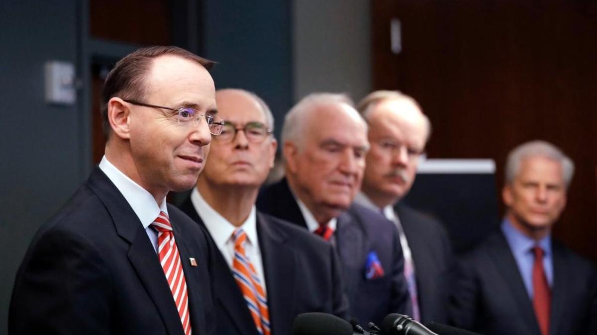 Deputy Attorney General Rod Rosenstein, left, speaks at a news conference giving an update on the unsolved 2001 slaying of a federal prosecutor, Wednesday, Feb. 21, 2018, in Seattle. Behind him stand former U.S. Attorneys John McKay, right, Bill Hyslop, Hal Hardin and Mike McKay. Rosenstein joined other officials to discuss the killing of Assistant United States Attorney Thomas Wales, an 18-year veteran of the U.S. Attorney's Office in Seattle who was shot as he worked in the basement of his home on Oct. 11, 2001. (AP Photo/Elaine Thompson)