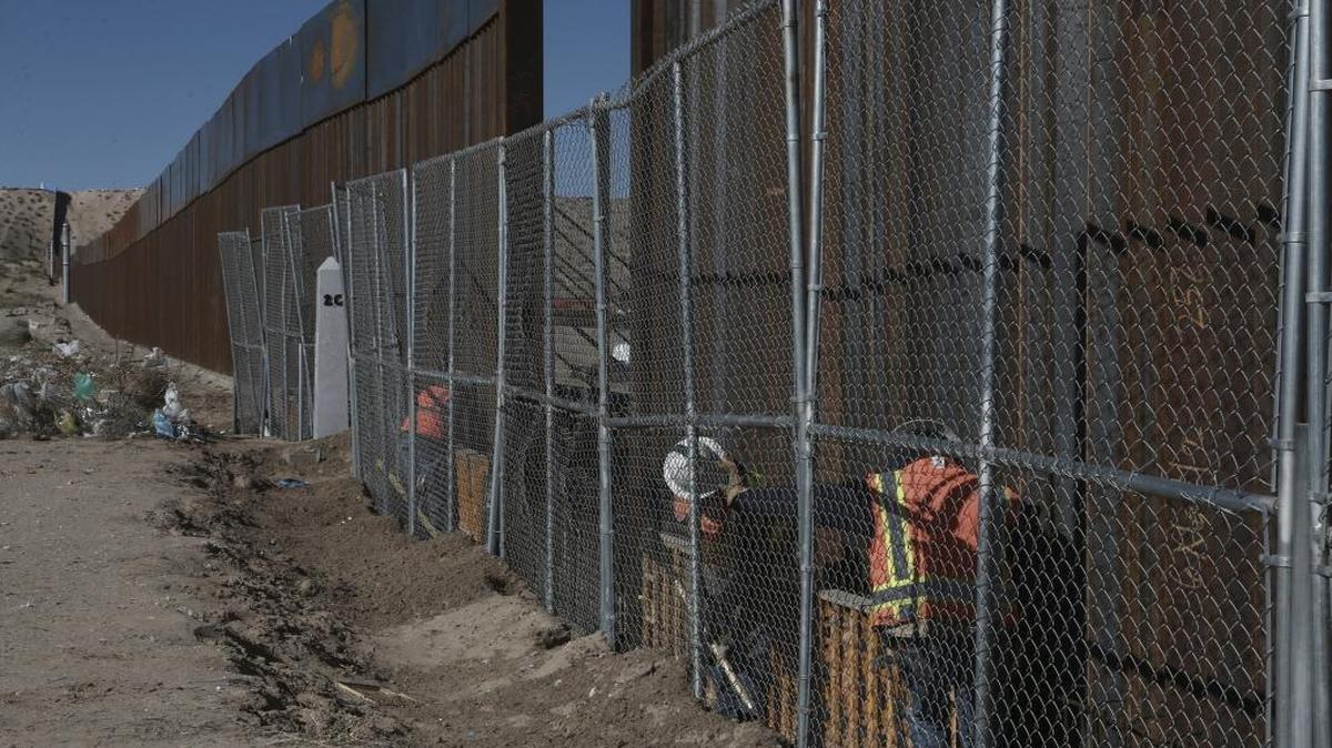 Workers raise a taller fence on the Mexico-US border separating the towns of Anapra, Mexico and Sunland Park, N.M.