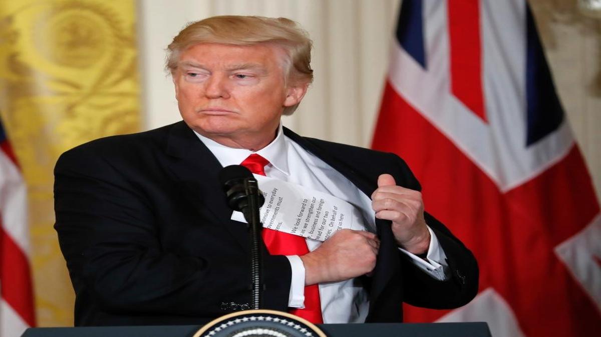 President Donald Trump tucks away his notes near the end of a joint news conference with British Prime Minister Theresa May in the East Room of the White House in Washington, Jan. 27, 2017.