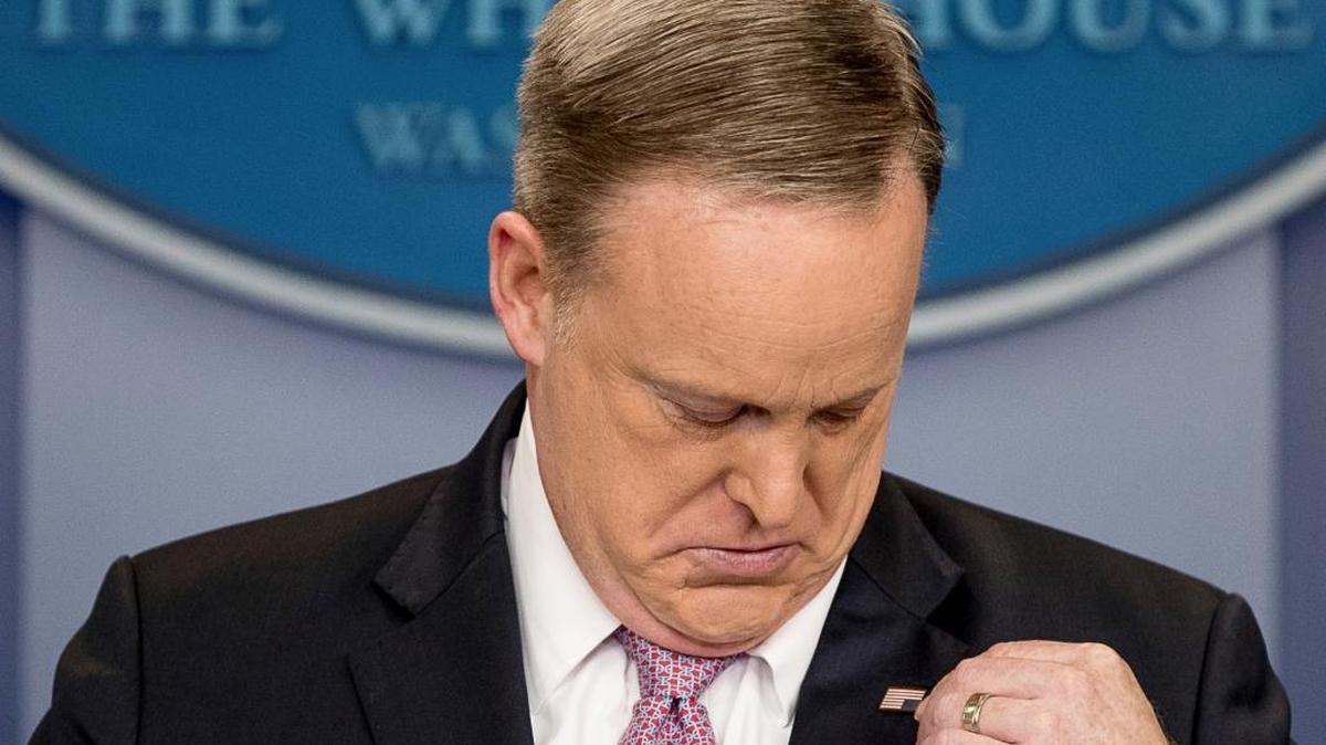 White House press secretary Sean Spicer adjusts his American flag pin after he was told that it was upside down, Friday, March 10, 2017, during the daily press briefing at the White House in Washington.