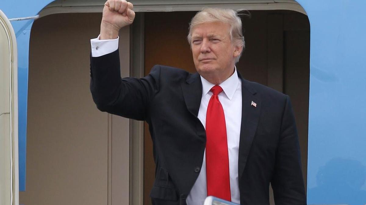 President Donald Trump gestures from the stairs of Air Force One upon his arrival at Palm Beach International Airport in West Palm Beach, Fla. Friday, March 3, 2017.