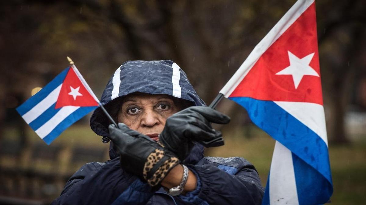 Violetta Pons of Miami, Fla., holds Cuban flags to raise awareness of continued oppression and human rights abuses by the Castro regime during a rally across the street from the White House in Washington, D.C., on Dec. 17, 2015.