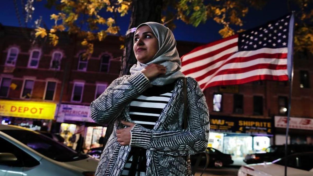 Enas Almadhwahi, an immigration outreach organizer for the Arab American Association of New York, stands for a photo along Fifth Avenue in the Bay Ridge neighborhood of Brooklyn on Nov. 11, 2016, in New York. American Muslims are reeling over Donald Trump's victory, wondering what the next four years will bring after a campaign in which he proposed creating a national database of Muslims, monitoring all mosques and banning some or all Muslims from entering the country.