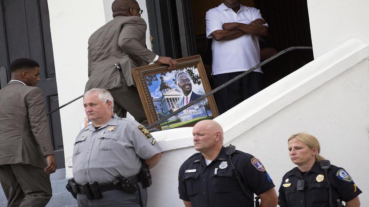 
A portrait of Sen. Clementa Pinckney, one of the nine killed in last week's shooting, is carried in for his wake at Emanuel AME Church, Thursday, June 25, 2015, in Charleston, S.C. The first funerals of some of those slain began Thursday at nearby churches with a viewing for Pinckney inside Emanuel on Thursday evening. President Barack Obama will deliver the eulogy at Pinckney's funeral Friday at a nearby college arena. 
