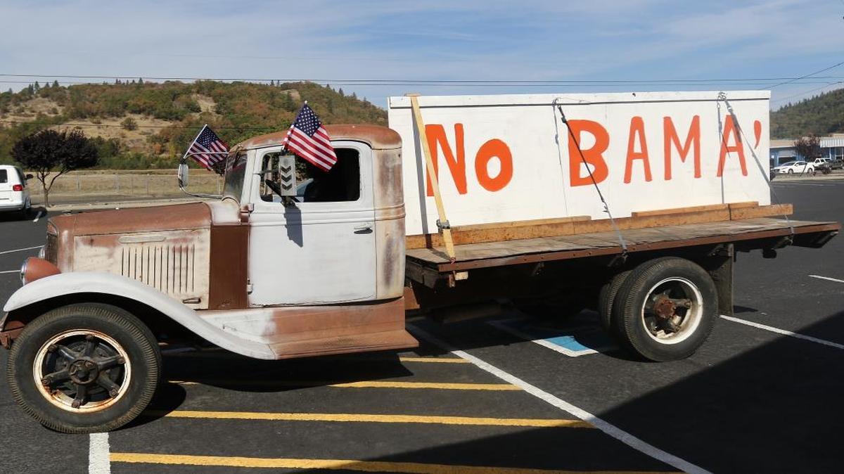 
Gary Shamblin of Winston, Ore. prepares to leave a parking lot in Roseburg, Ore., on Thursday Oct. 8, 2015, in his 1934 International truck displaying a sign he made reflecting his views on President Obama's planned visit to the area. 

