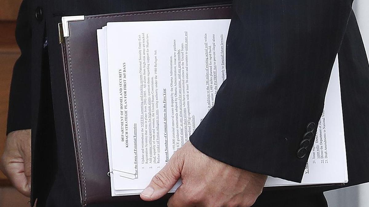 Kansas Secretary of State Kris Kobach carries a document out of a meeting with Donald Trump on Sunday, Nov. 20, 2016, that suggests he may be in line for a position at the Department of Homeland Security.