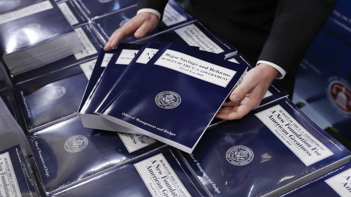 Eric Ueland, Republican staff director, Senate Budget Committee, lays out copies of President Donald Trump’s fiscal 2018 federal budget before distributing them to congressional staffers, Tuesday, May 23, 2017, on Capitol Hill in Washington.