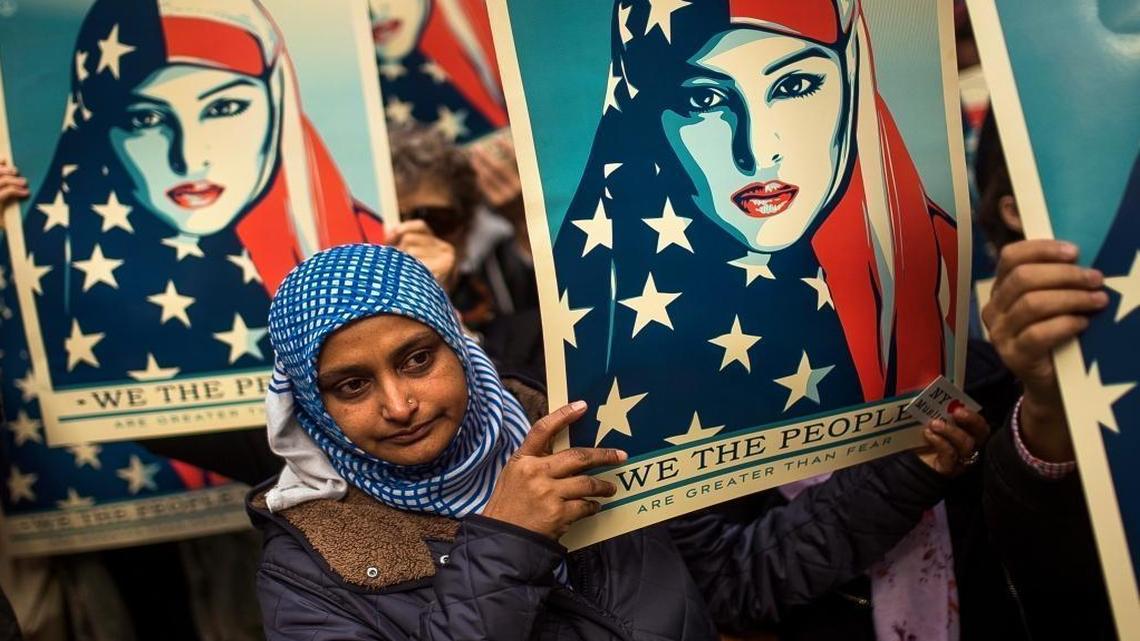 People carry posters during a rally against President Donald Trump's executive order banning travel from seven Muslim-majority nations, in New York's Times Square, Sunday, Feb. 19, 2017.
