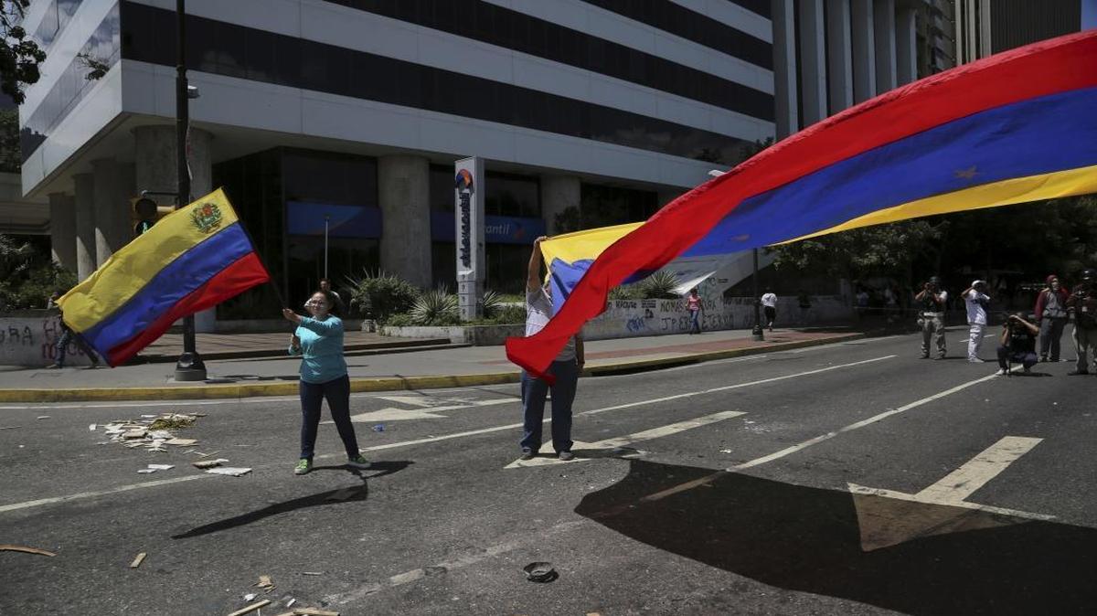 Anti-government demonstrators wave Venezuelan national flags during a protest against Venezuela's President Nicolas Maduro in Caracas, Venezuela, Tuesday, Aug. 8, 2017.