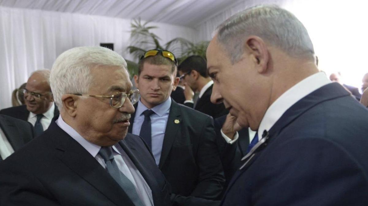 President Mahmoud Abbas, left, shakes hands with Israeli Prime Minister Benjamin Netanyahu, right, at the funeral for former President Shimon Peres in Jerusalem on Sept. 30, 2016