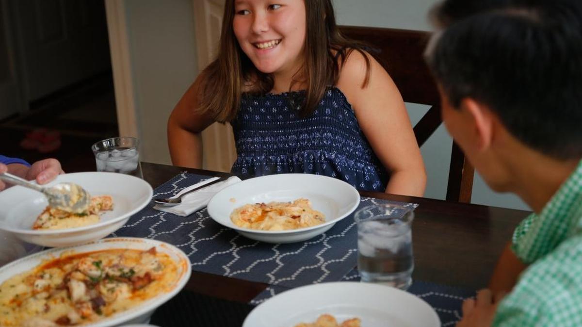 Mena Choi, 10, laughs with her father, Steve Choi, during dinner in their Chapel Hill, N.C., home on July 8, 2016.