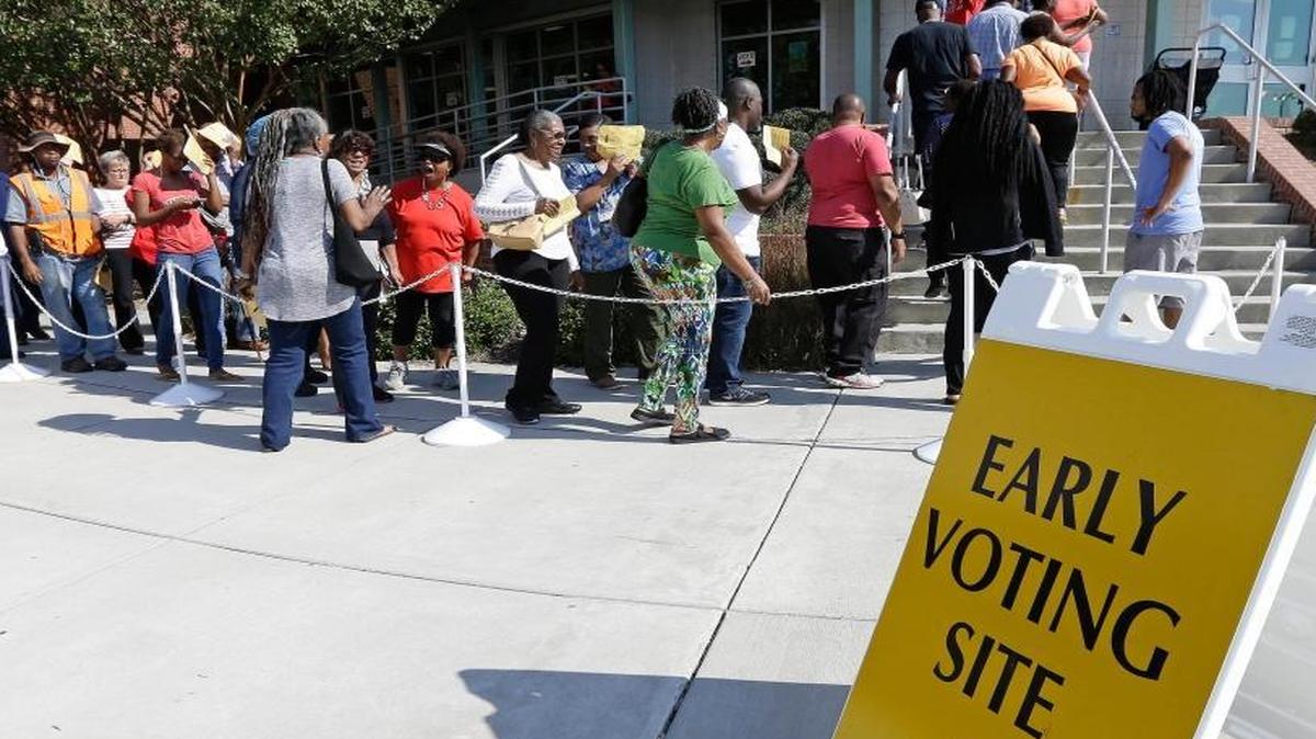 In this Oct. 20, 2016 file photo, voters line up during early voting at Chavis Community Center in Raleigh, N.C. More than a dozen states have enacted tougher requirements for registering and voting since the U.S. Supreme Court overturned a key provision of the Voting Rights Act three years ago. That has led to confusion and claims that certain groups, mostly minorities who tend to vote with Democrats, are being disenfranchised.